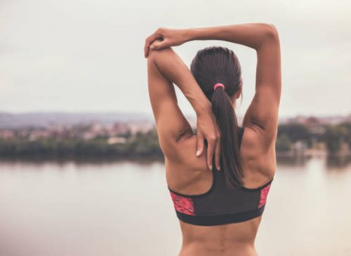 Woman stretching and exercising outdoor.Image is intentionally toned.